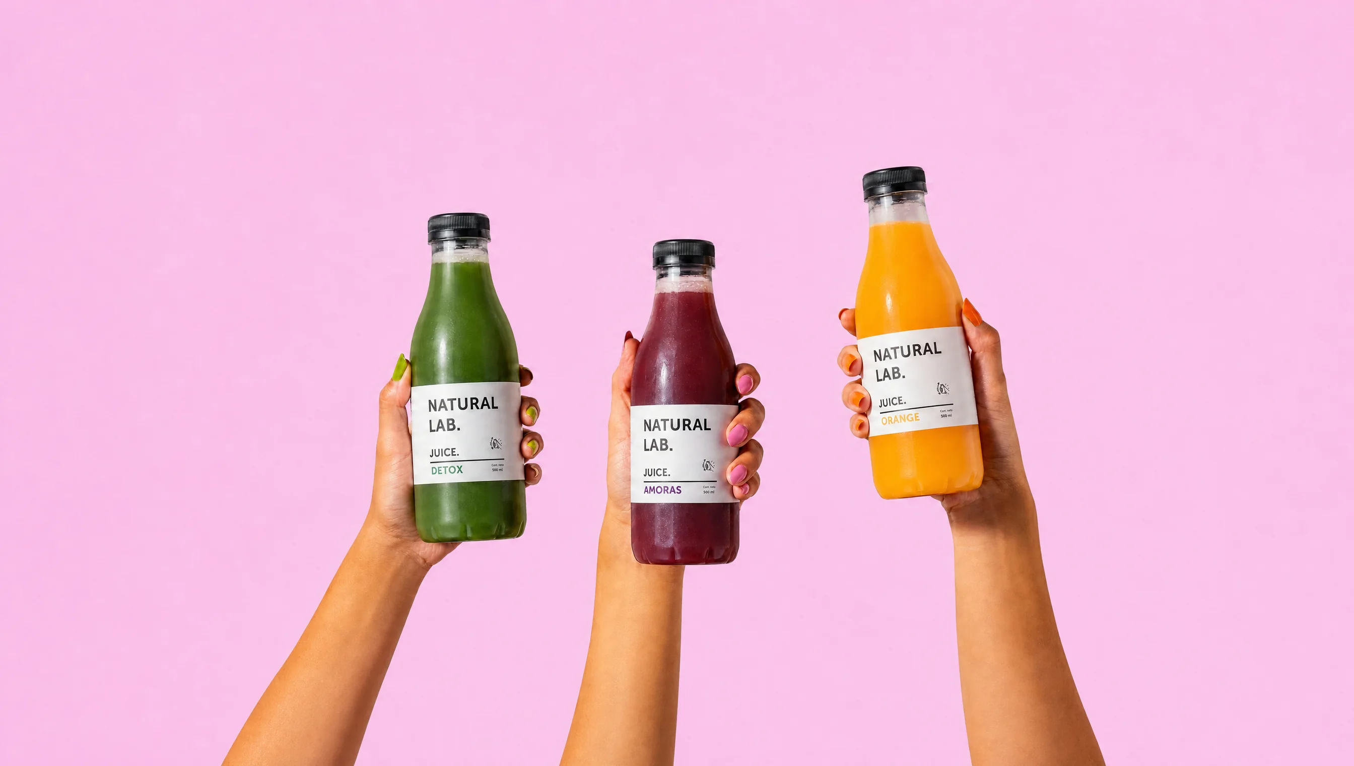 Tres jugos Natural Lab sostenidos con las manos